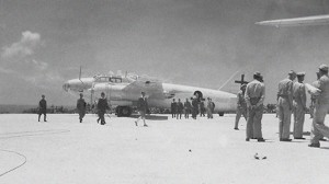 The Japanese delegation walking across the hard-packed coral toward the waiting American reception committee under the C-54 that would carry them to the Philippines.  Photo Credit: Combat Air Museum